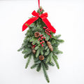 Noblis fir  branches, a large red ribbon bow at the top, red berries, and  pinecones.